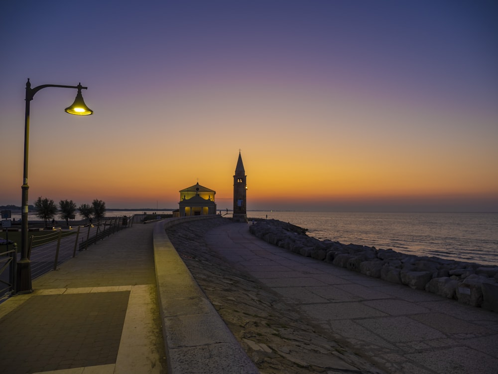 a street light sitting next to a body of water