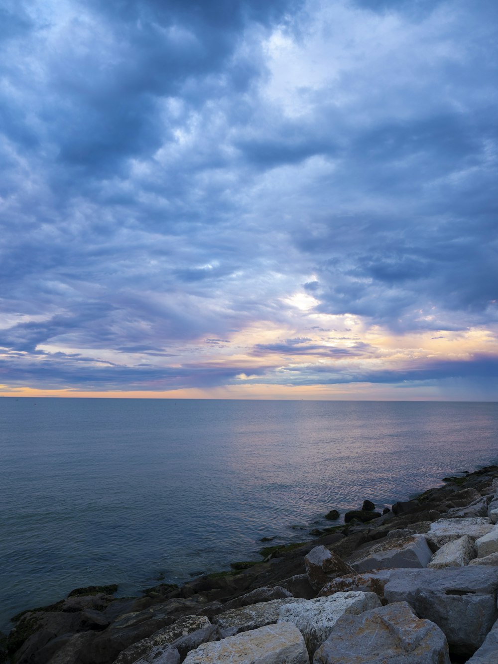 a large body of water sitting under a cloudy sky