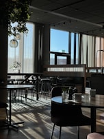 Sunlight streaming through large windows onto a clean, inviting café space.
