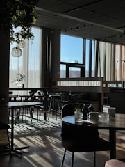 Warm café interior with comfy chairs and morning sunlight.