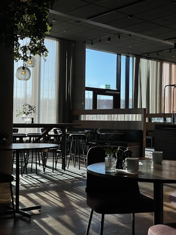 A cozy corner inside orobites café with sunlight streaming through windows, showing customers enjoying coffee and pastries.