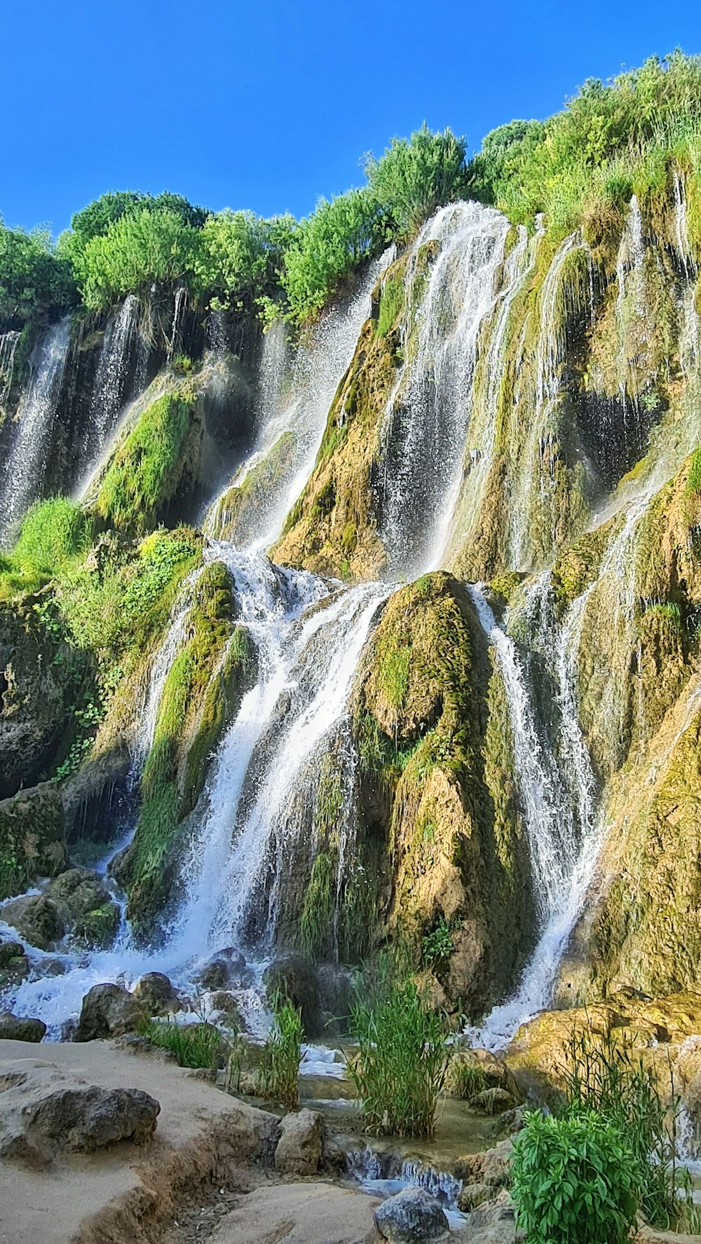 a large waterfall with lots of water cascading it's sides