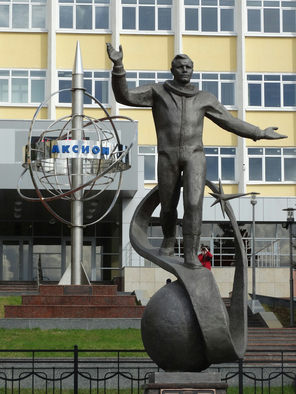 a statue of a man holding a globe in front of a building