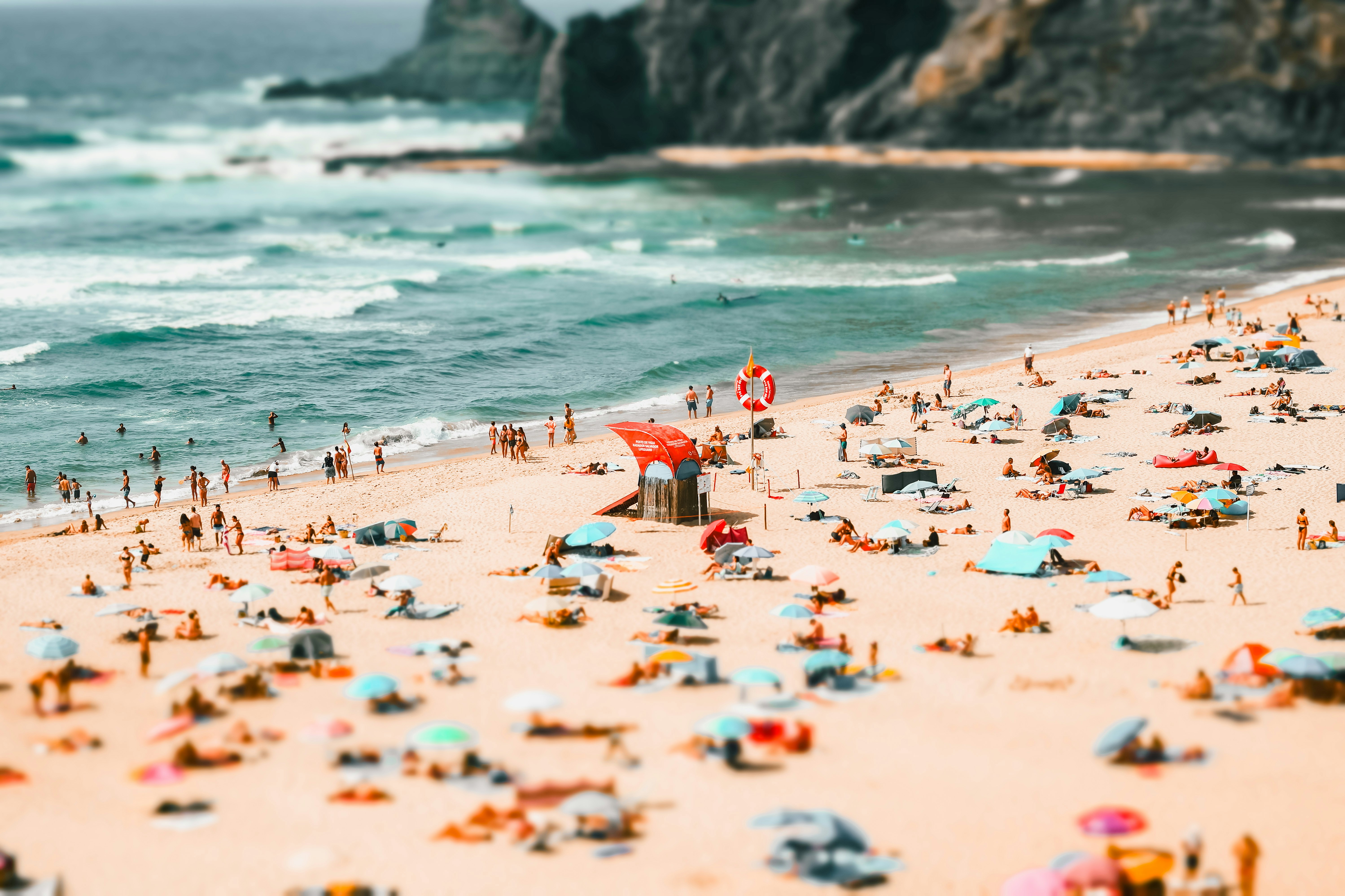 a beach filled with lots of people and umbrellas