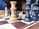A close-up view of a chessboard with wooden pieces in play. The focus is on the kings and queens, prominently positioned on the board. The background is slightly blurred, hinting at a warm and calm indoor setting. The chess pieces are made of contrasting light and dark wood.