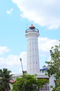 a tall white tower with a light on top