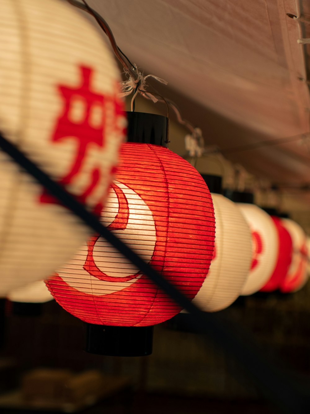 a row of red and white lanterns hanging from a ceiling