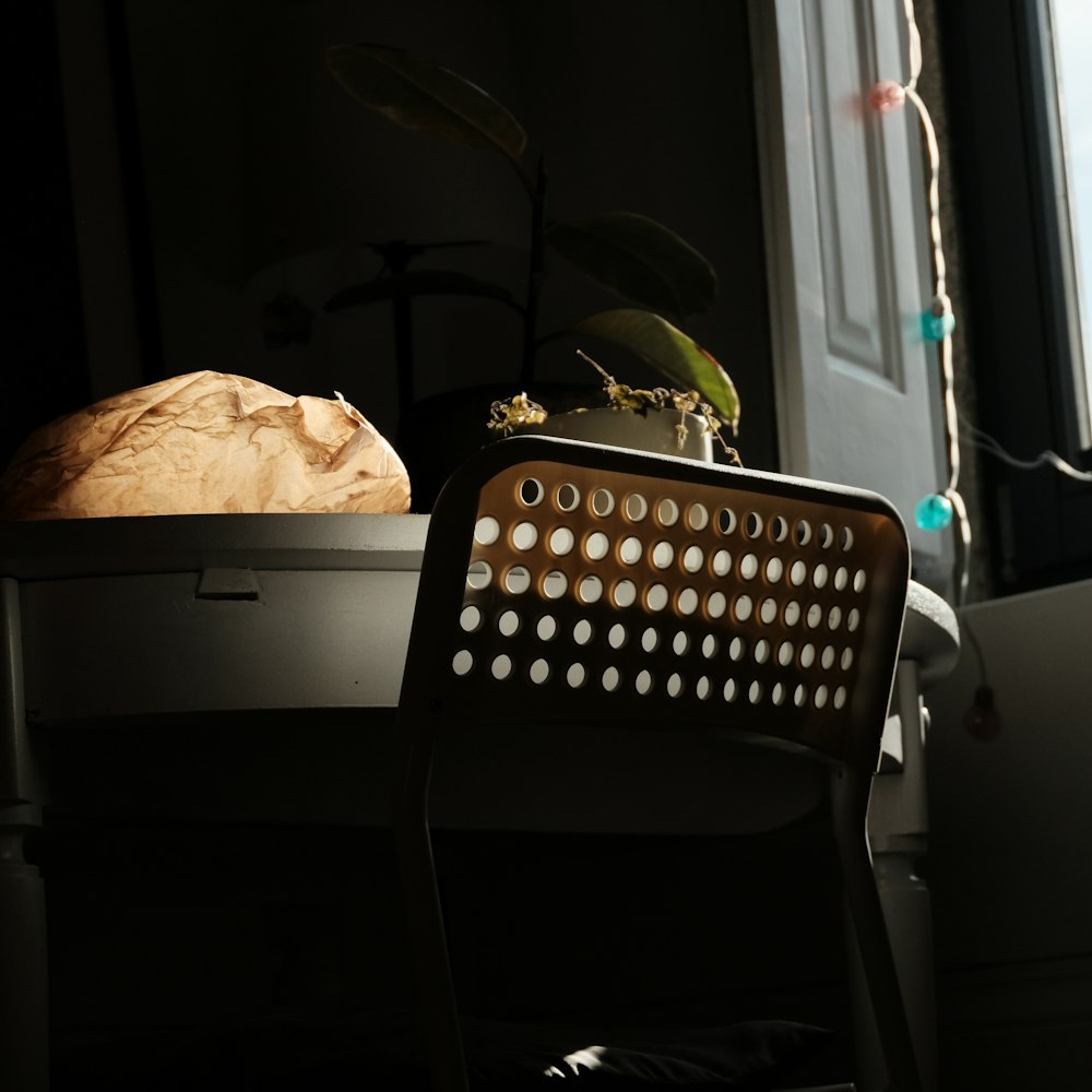 a chair sitting next to a table with a loaf of bread on top of it