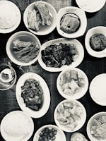 A vibrant spread of Malay, Chinese, and Western dishes arranged on a central kitchen counter.