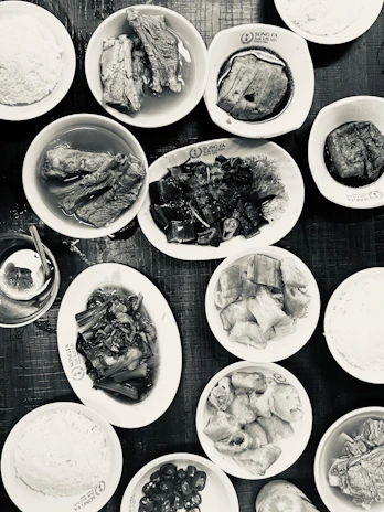 An overhead view of a beautifully arranged spread of diverse Indonesian cuisine presented on a rustic wooden table.