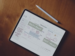 Close-up of hands organizing tasks on a digital planner on a tablet