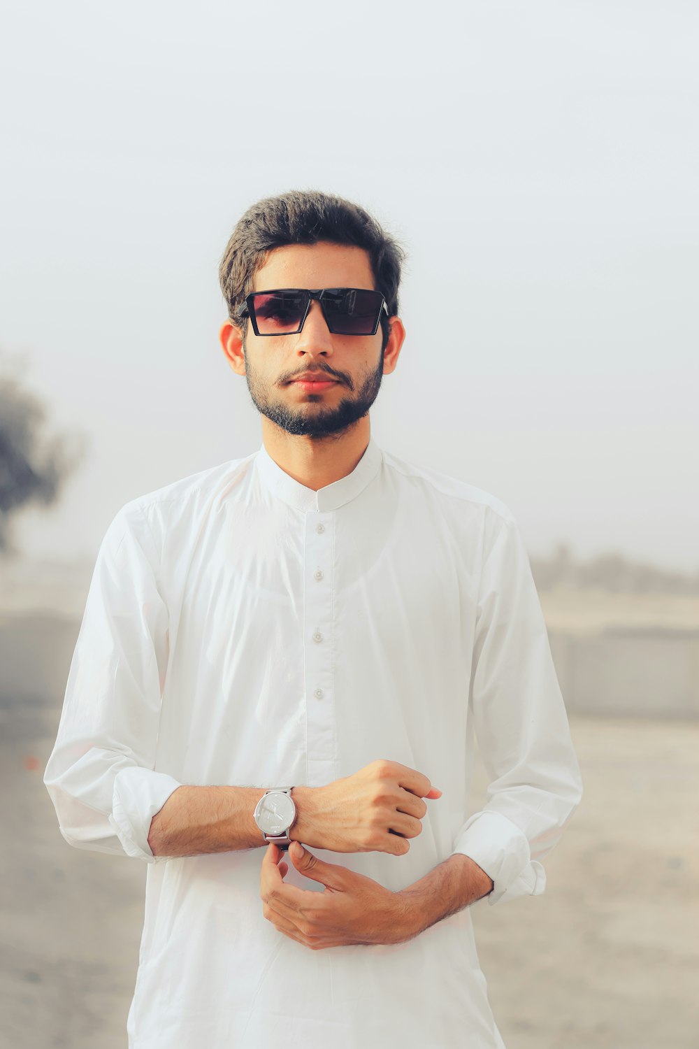 a man wearing sunglasses and a white shirt