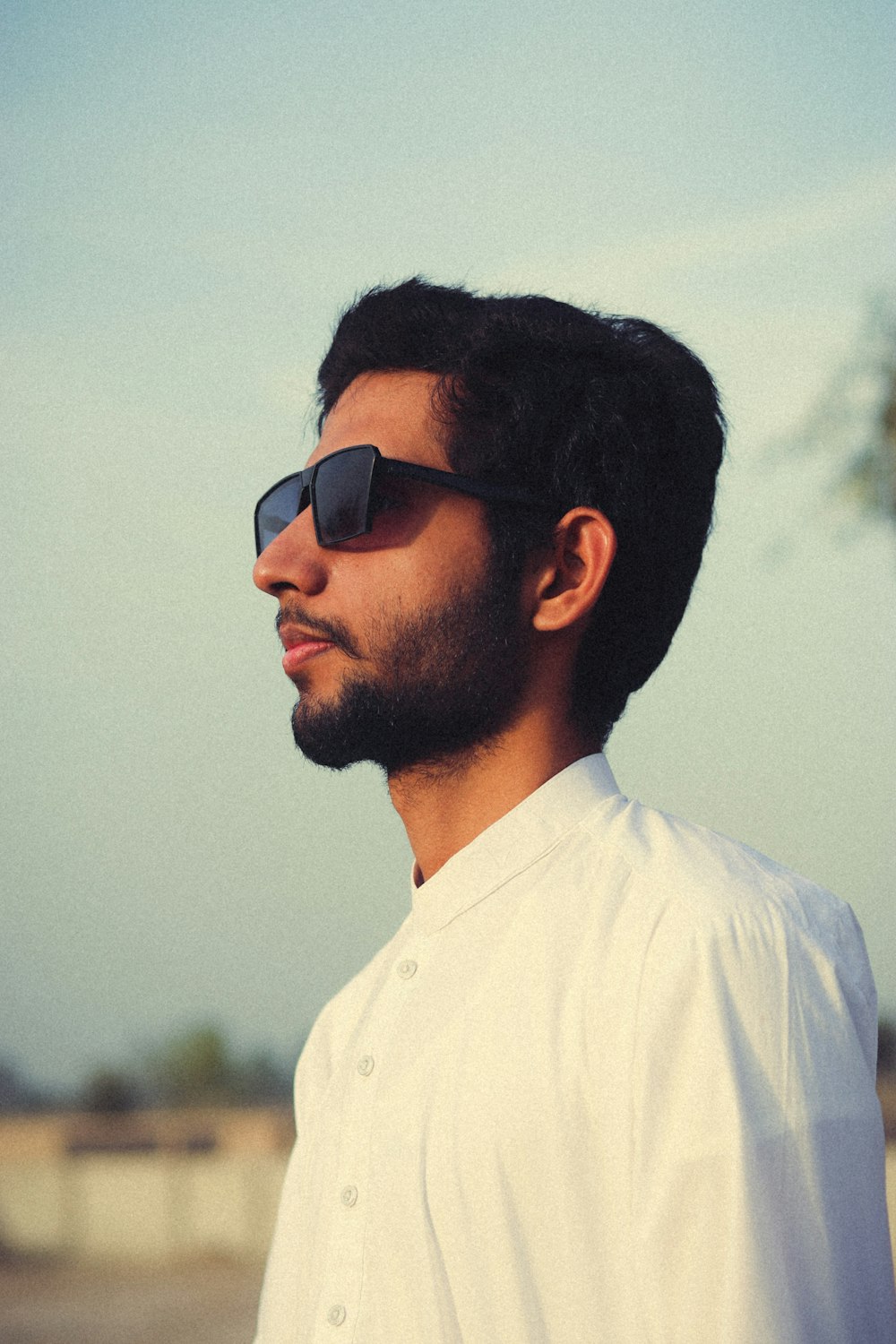 a man wearing sunglasses and a white shirt