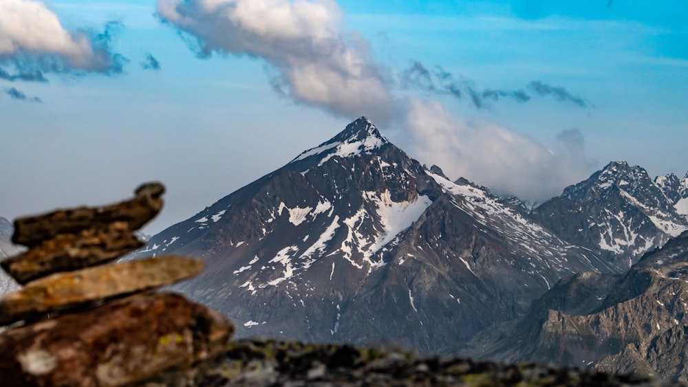 a mountain range with a stack of rocks in the foreground