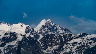 Snow-capped peaks of the Atlas Mountains with a clear blue sky.