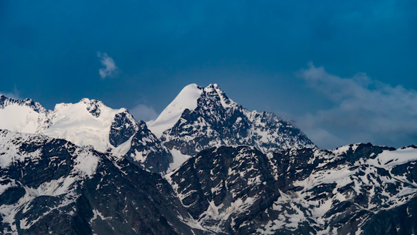 Snow-capped peaks of the Atlas Mountains with a clear blue sky.