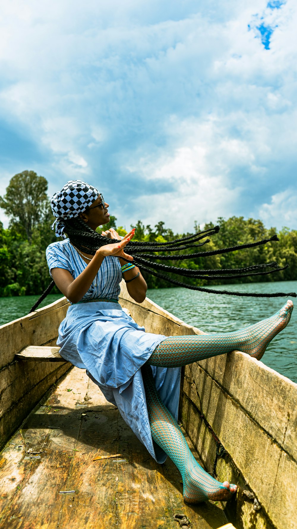 a woman in a blue dress sitting in a boat