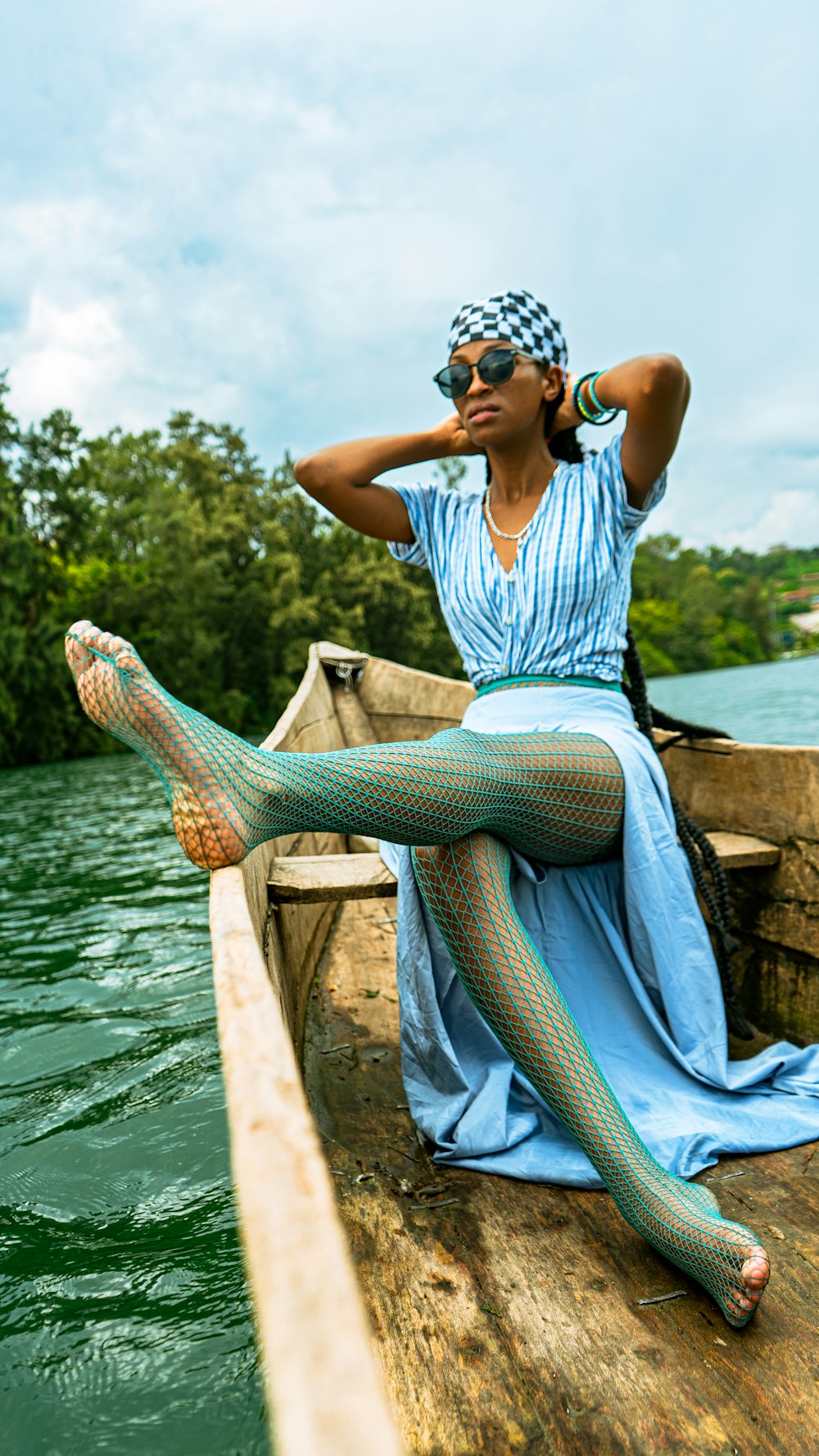 a woman in a blue dress is sitting on a boat