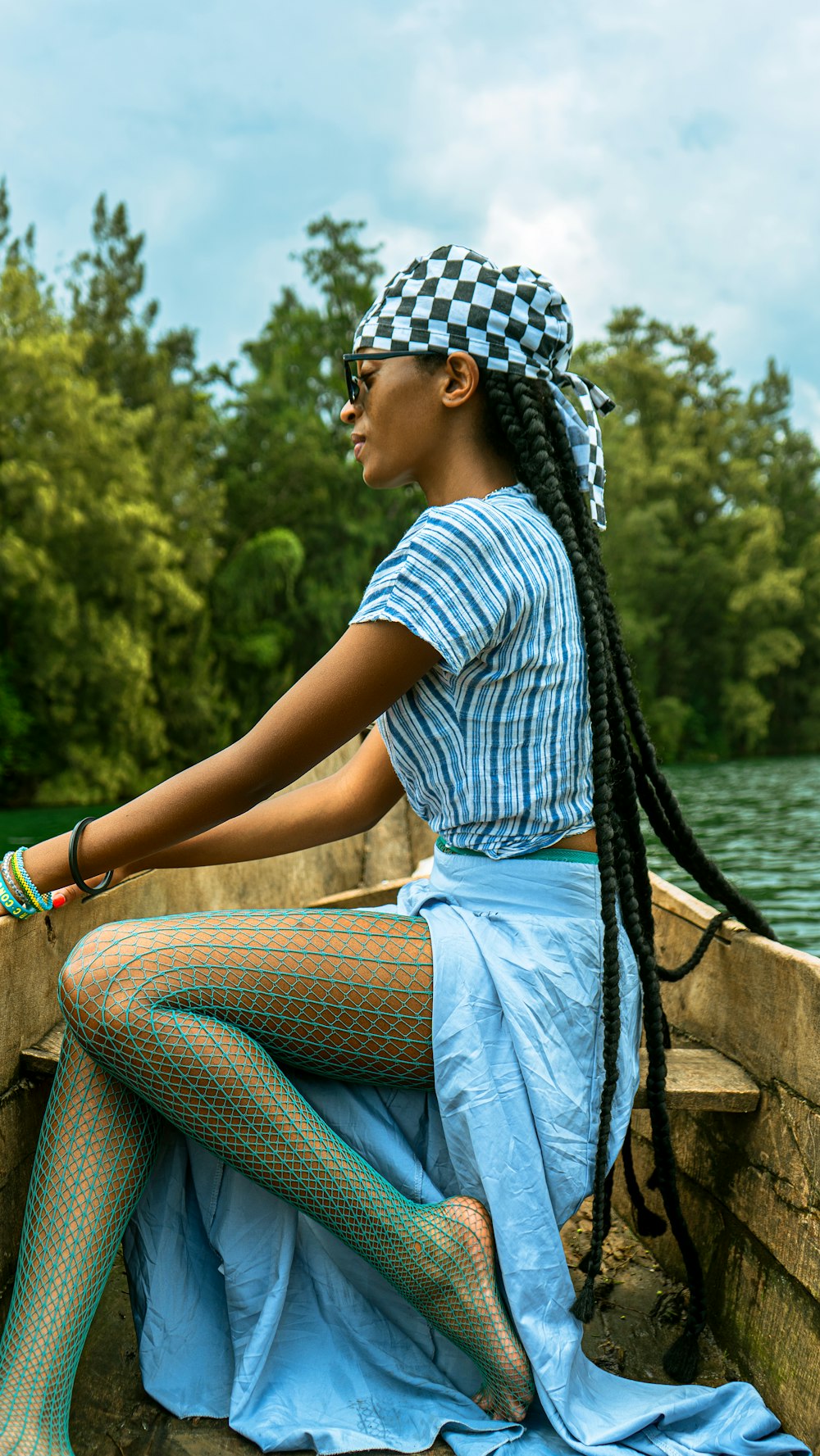 a woman sitting on a wall next to a body of water