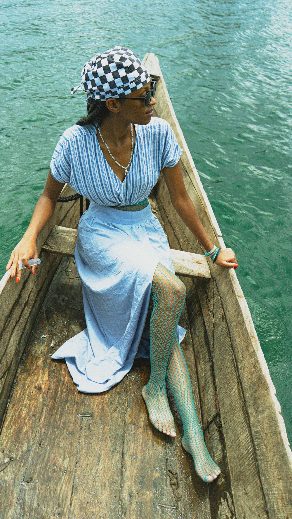 a woman sitting on a wooden boat in the water