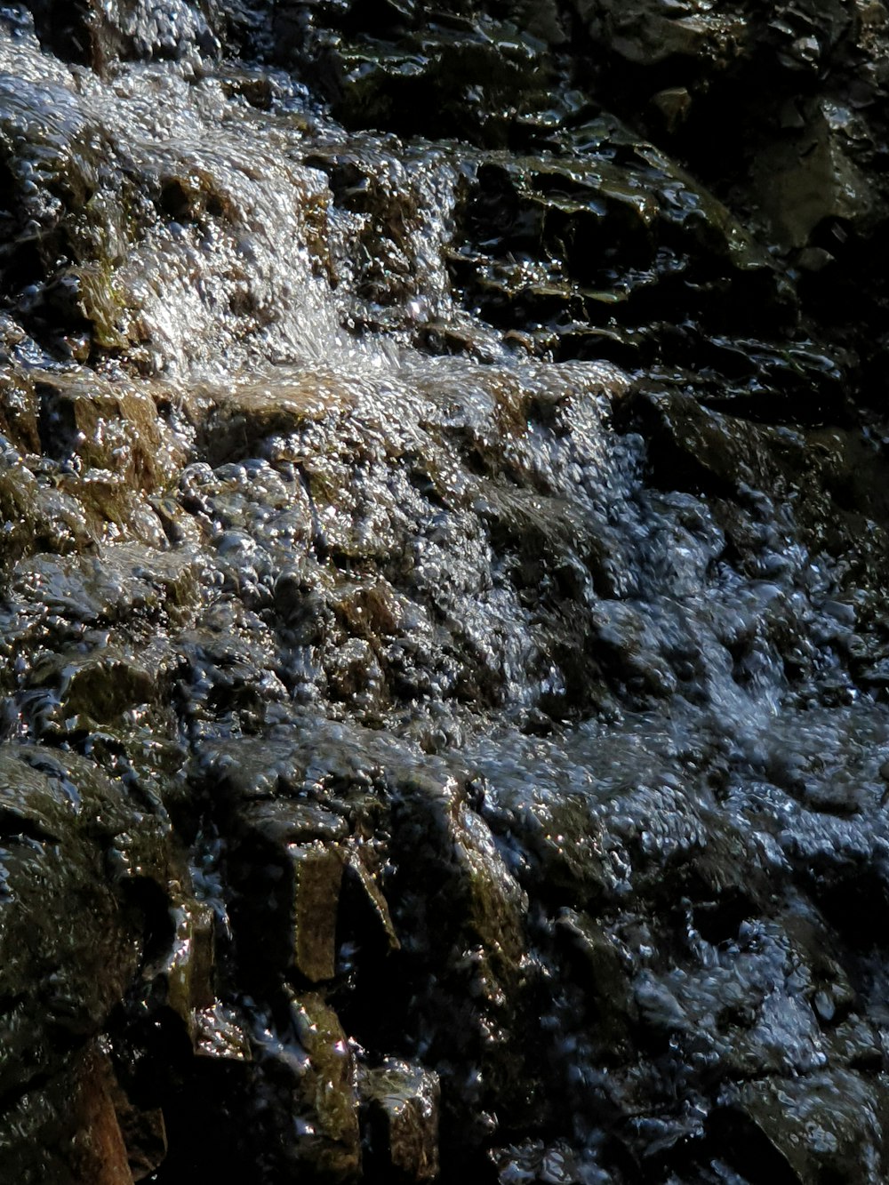 a close up of water flowing over rocks