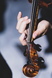 a close up of a person holding a violin