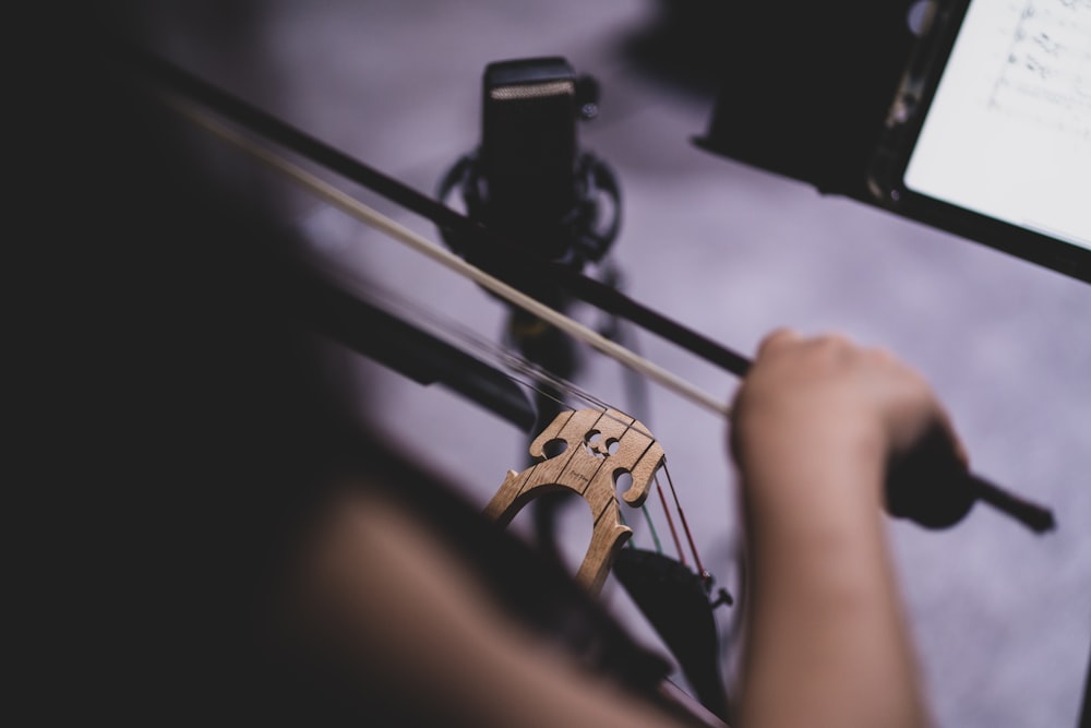 a person holding a violin string and a cell phone