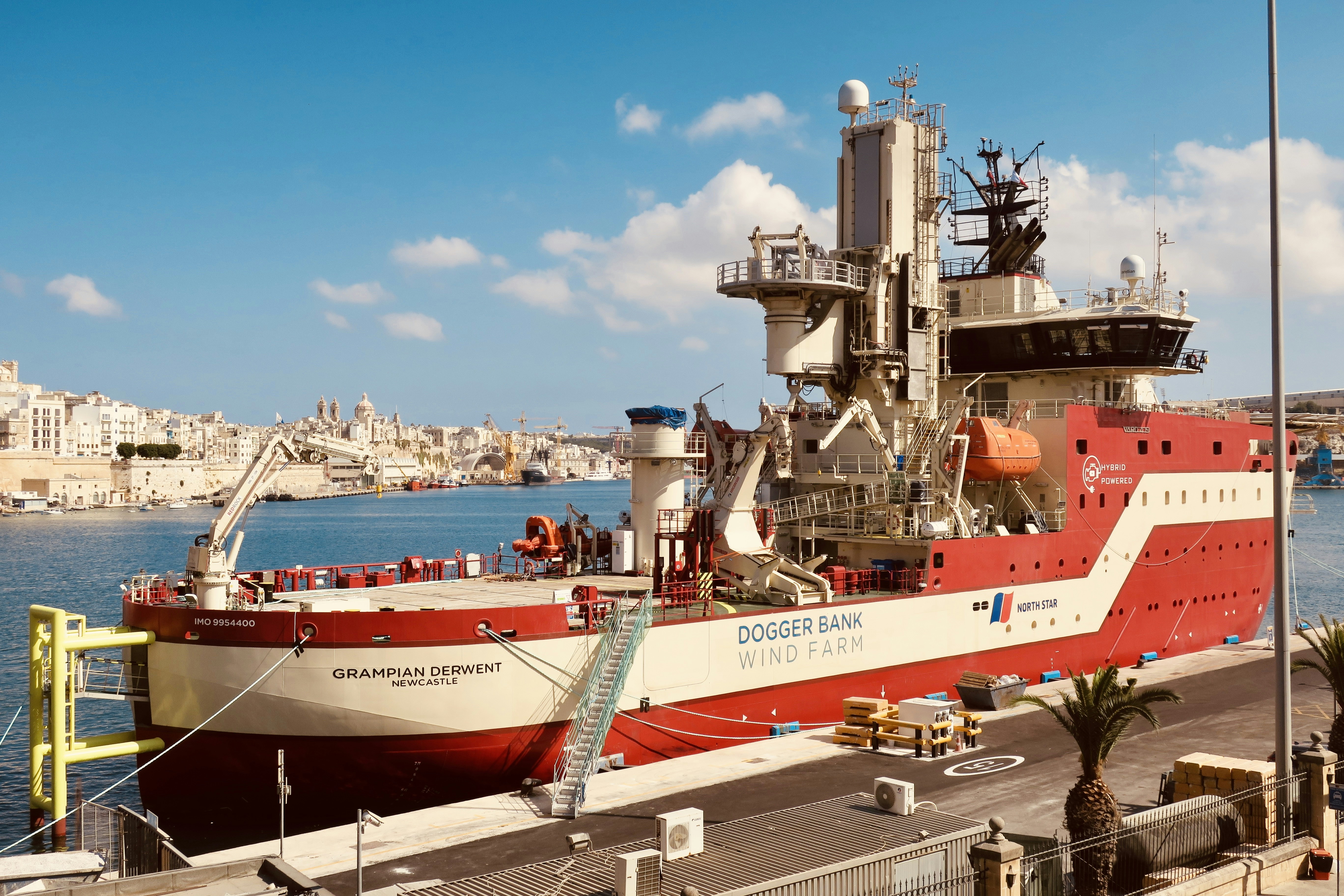 a large red and white boat docked at a pier
