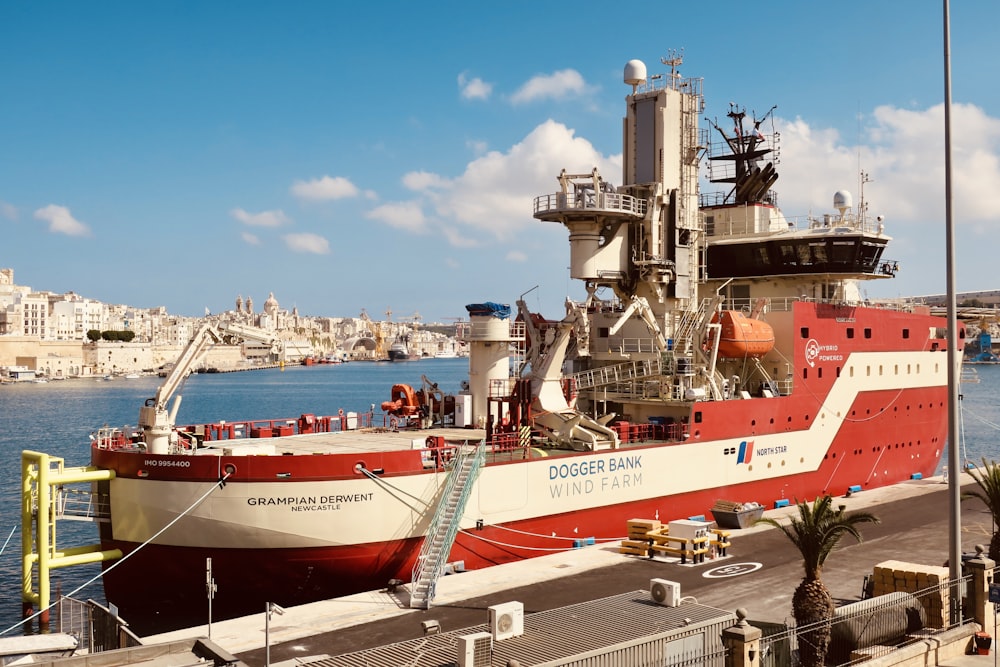 a large red and white boat docked at a pier