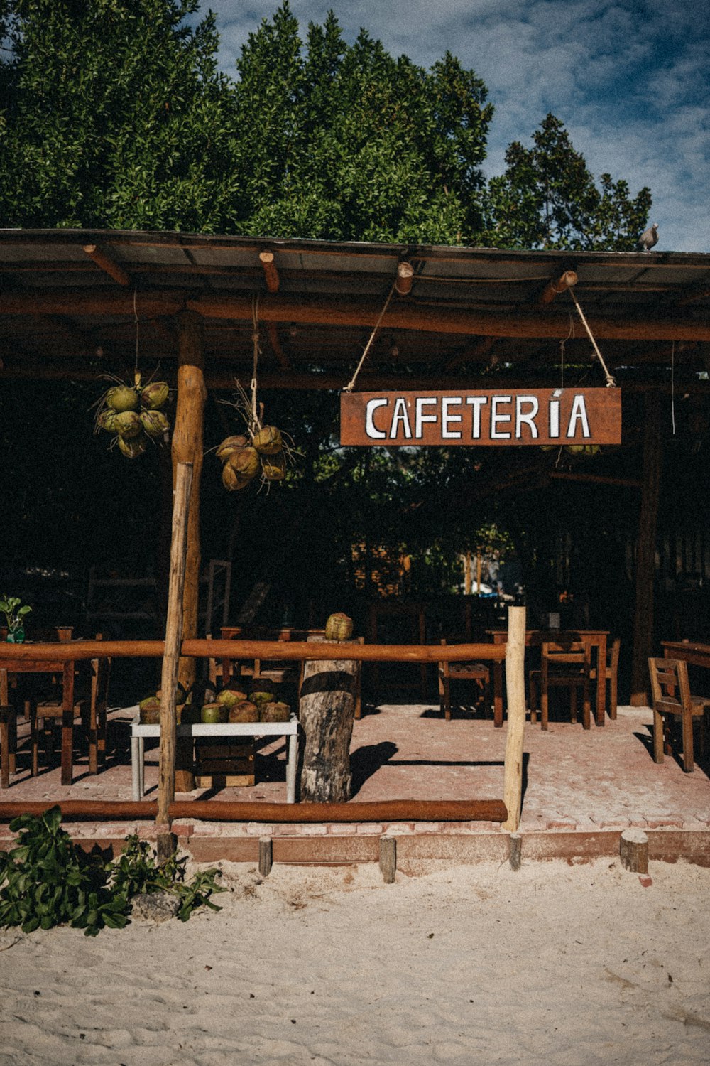 a sign that reads cafetera hanging from a wooden structure