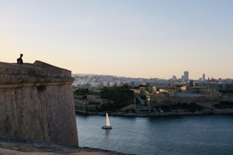 a sailboat in a body of water near a city