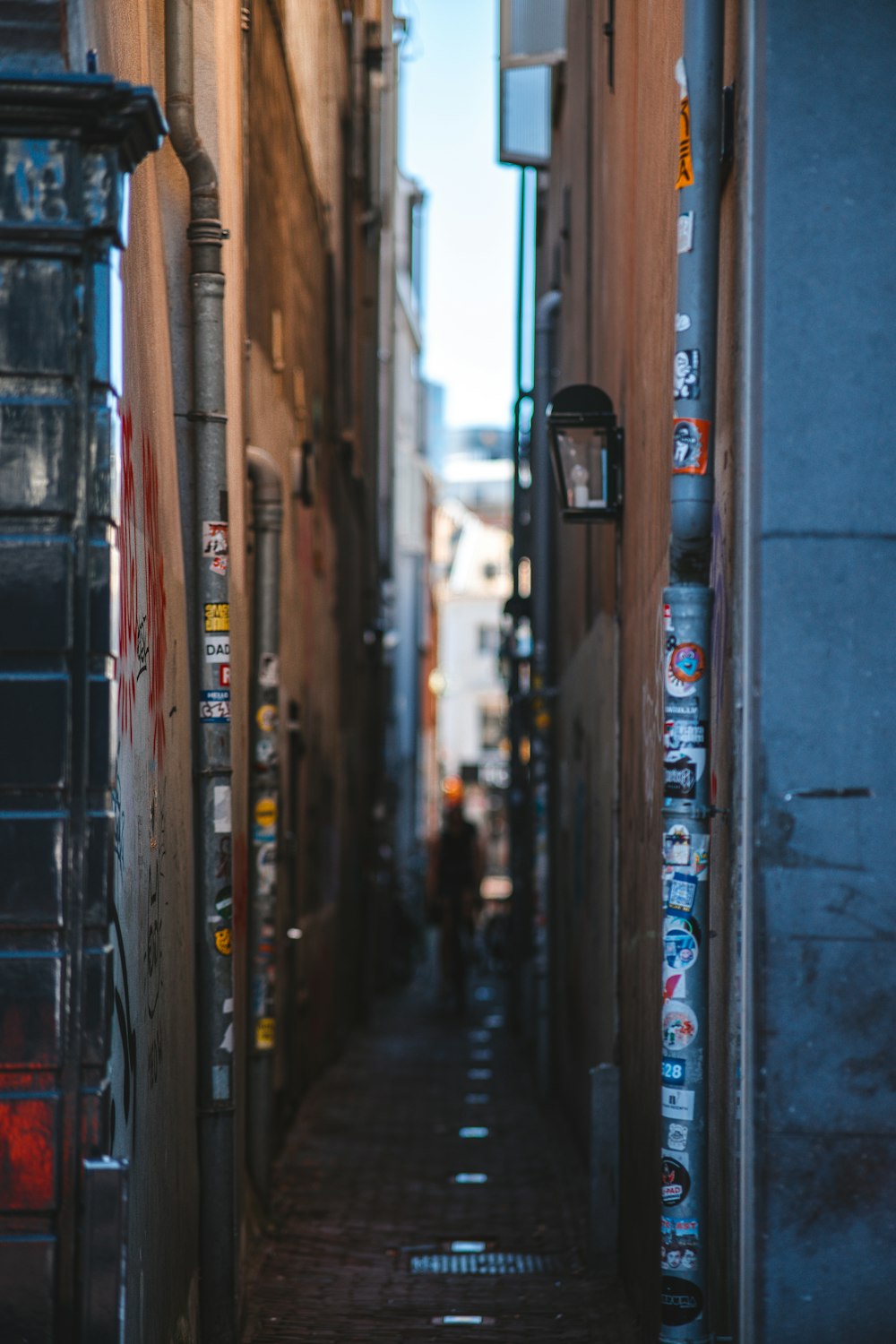 a narrow alley way with a person walking down it