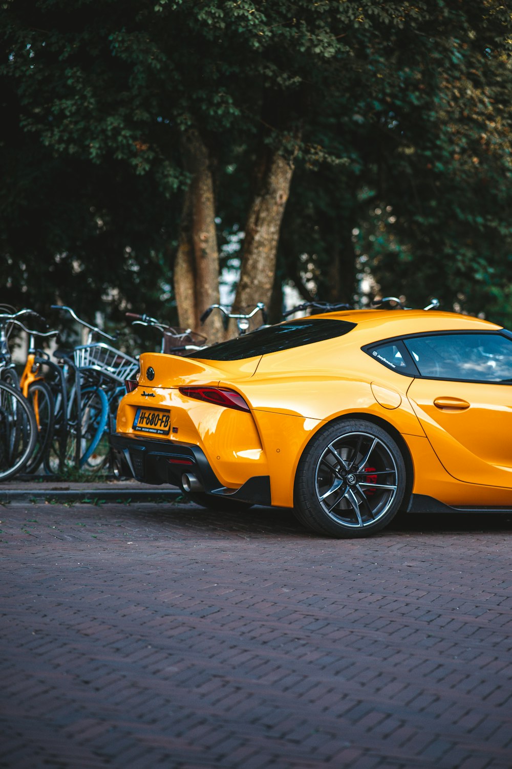 a yellow sports car parked on the side of the road