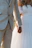 Close-up of a couple holding hands with soft sunlight in the background during their wedding video session.