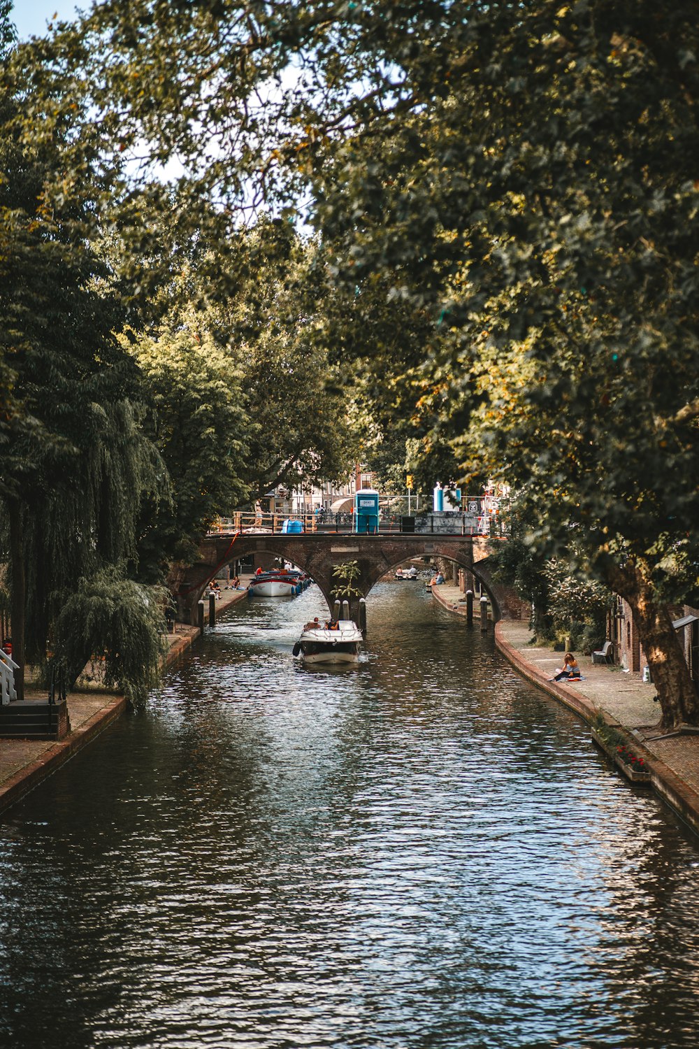 a boat traveling down a river under a bridge