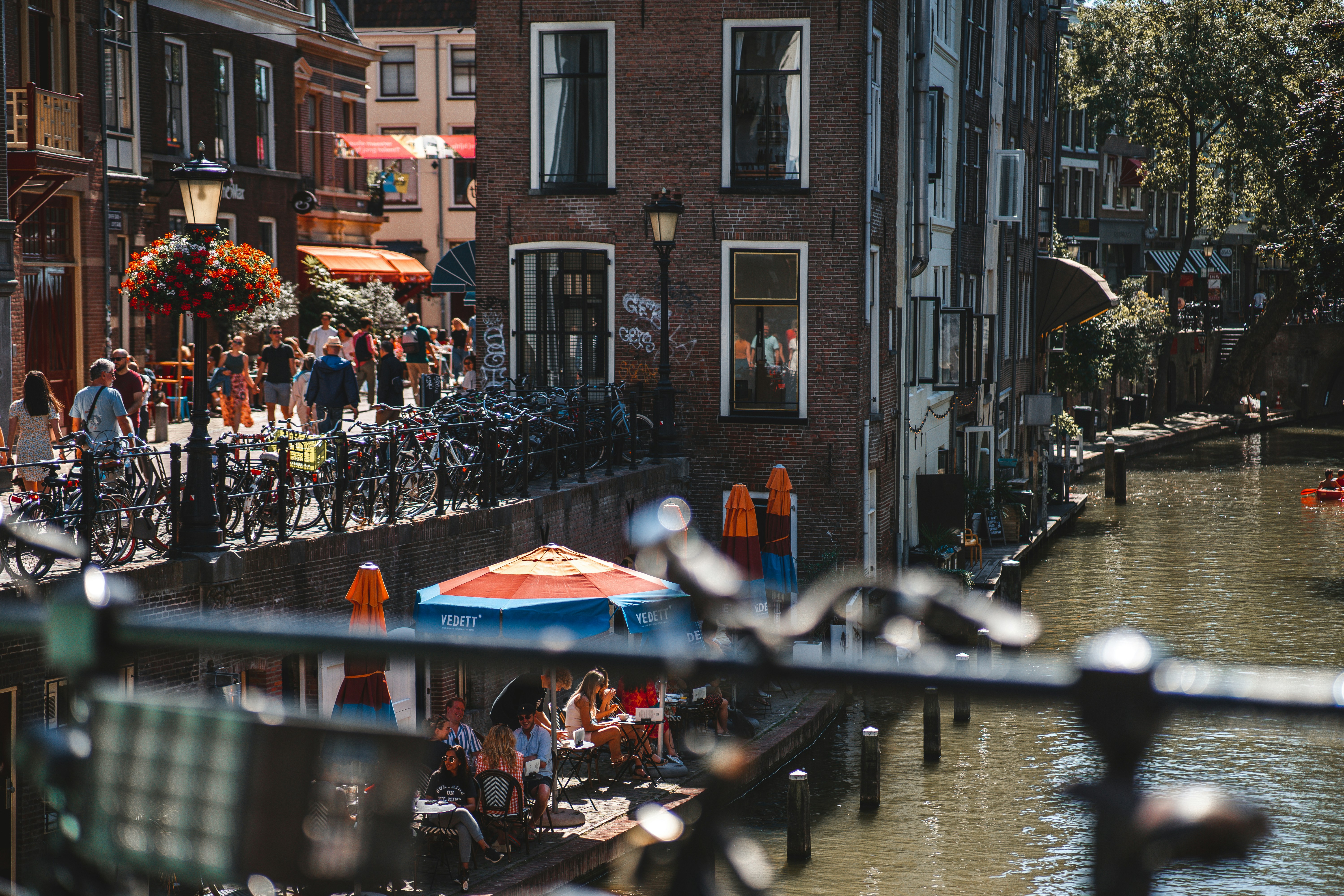a group of people riding bikes down a street next to a river, 