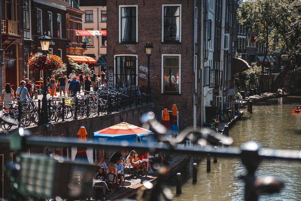 a group of people riding bikes down a street next to a river