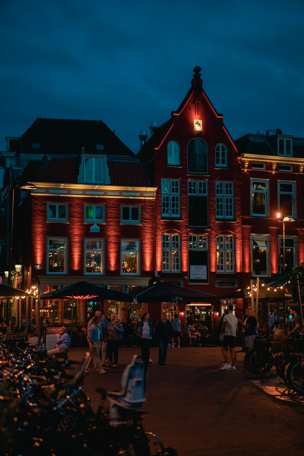 a group of people walking around a city at night