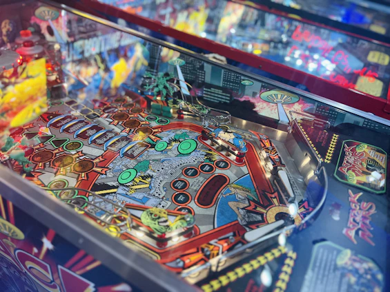 A colorful children-friendly pinball arcade machine glowing in a vibrant family entertainment center.