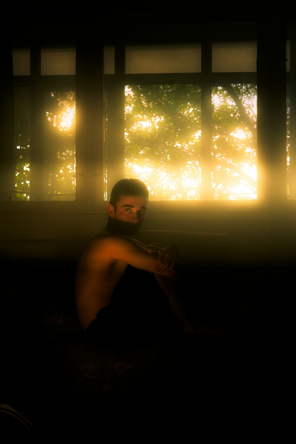 a man sitting on a couch in front of a window