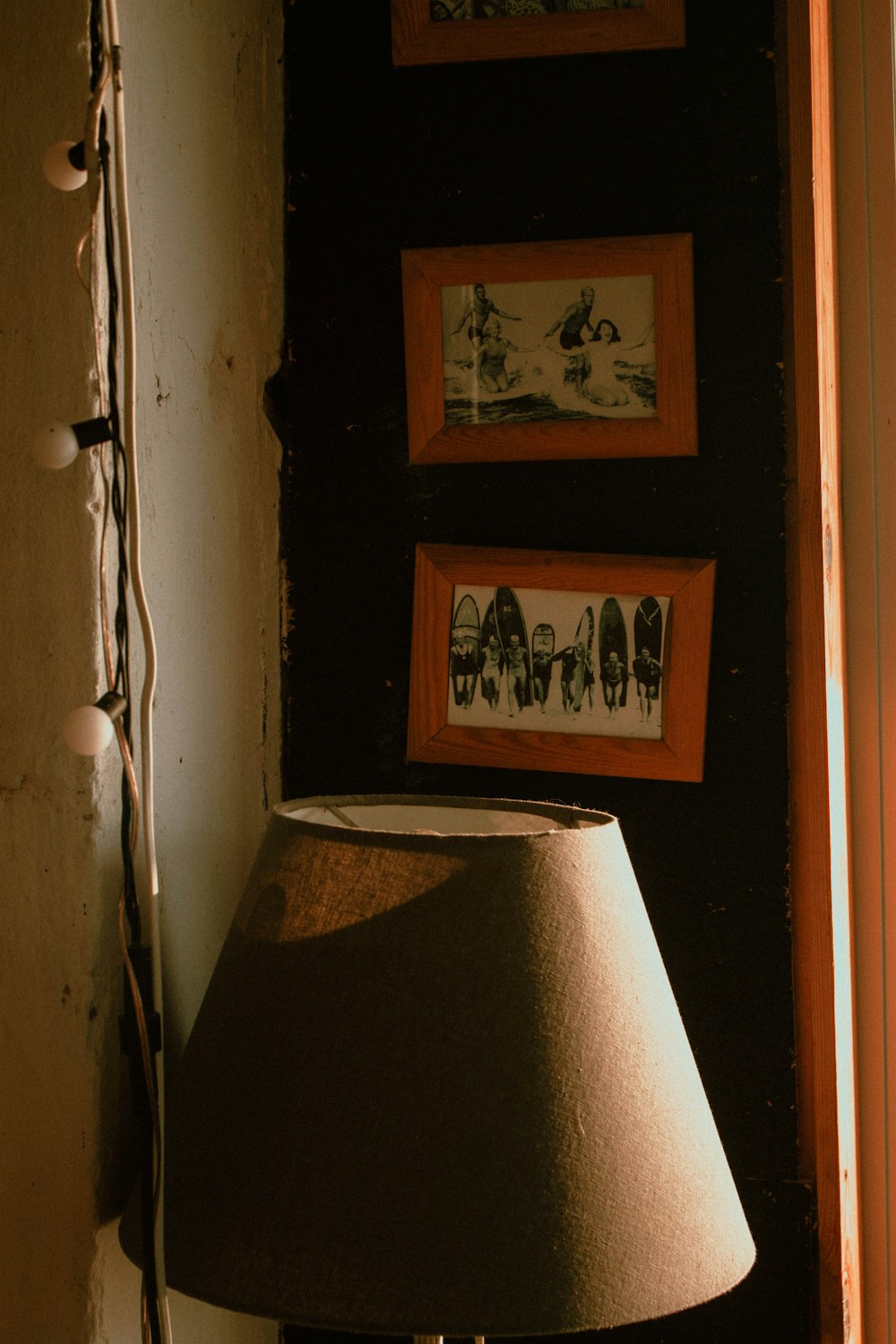 a lamp sitting next to a wall with pictures on it