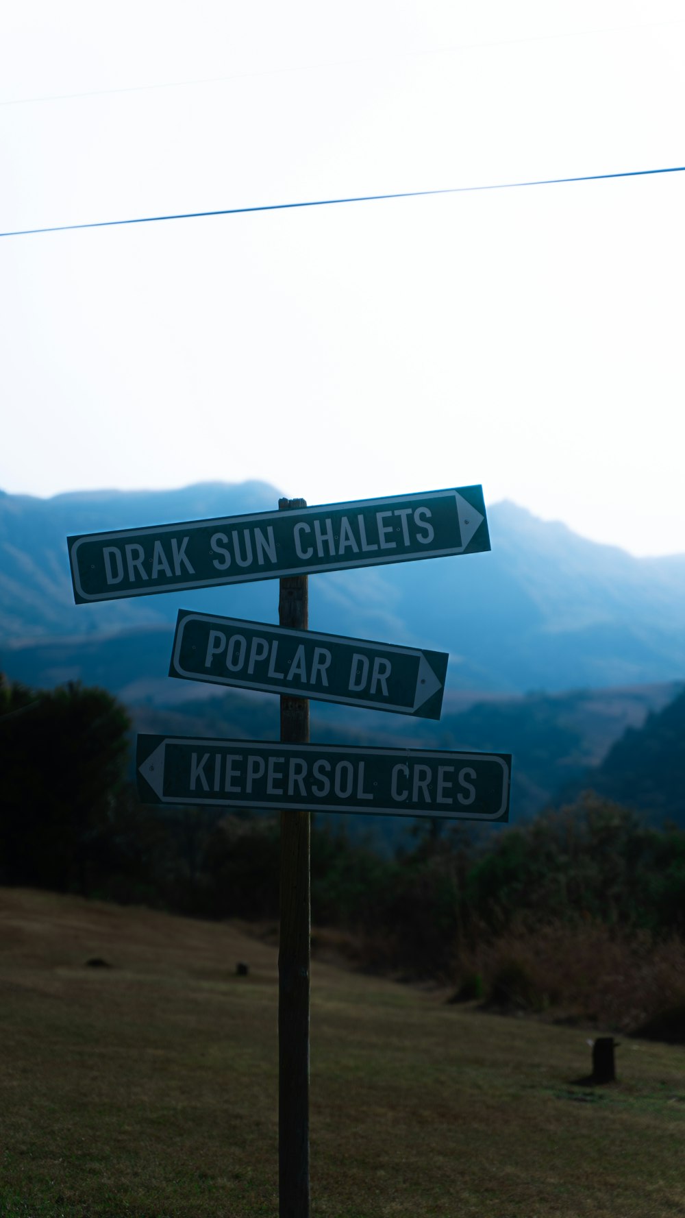 a street sign in front of a mountain range