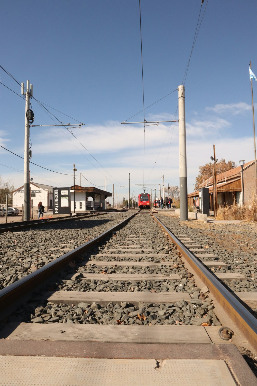 a red train traveling down train tracks next to a building