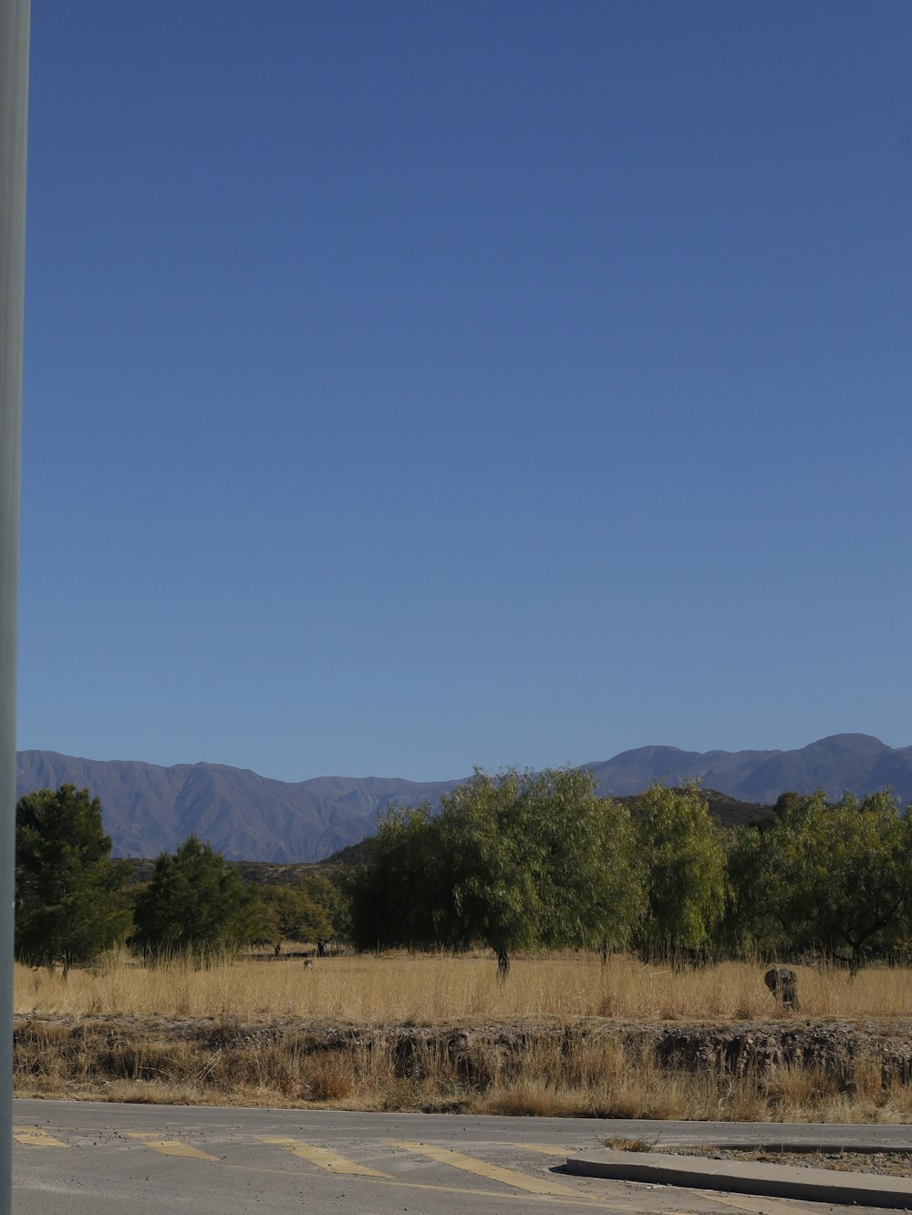 an empty parking lot with mountains in the background