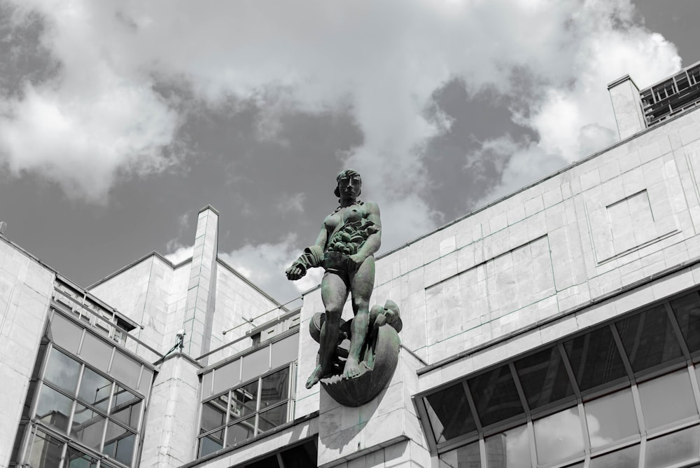 a statue of a man on a skateboard in front of a building