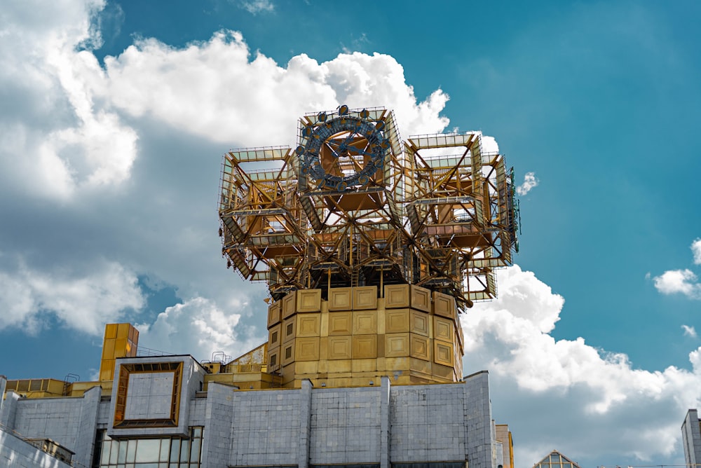 a large clock on top of a building under a cloudy blue sky