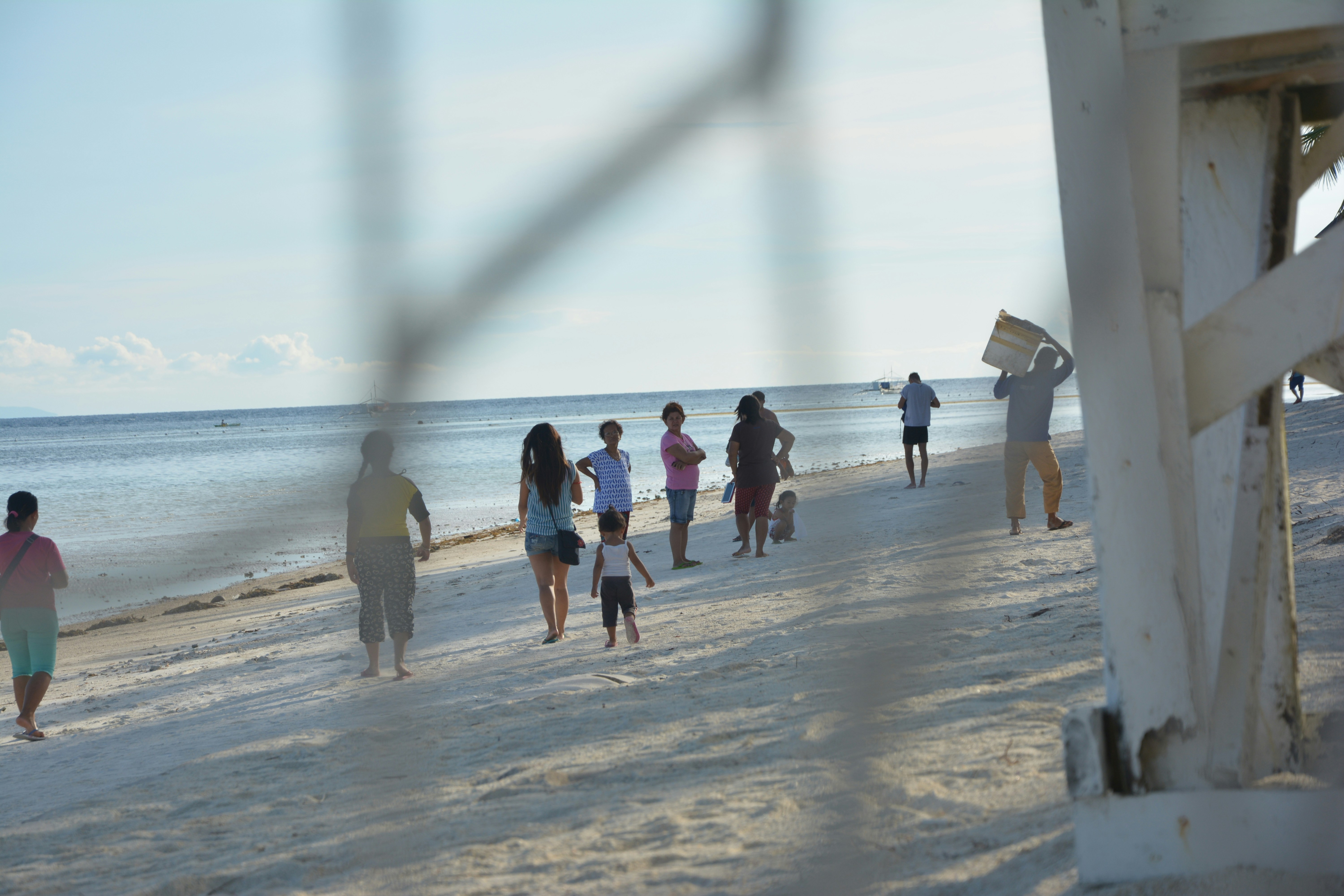 a group of people walking along a beach next to the ocean