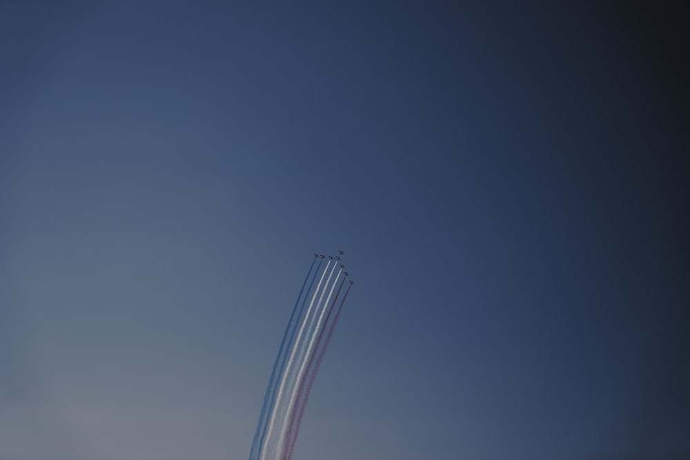 a group of airplanes flying through a blue sky