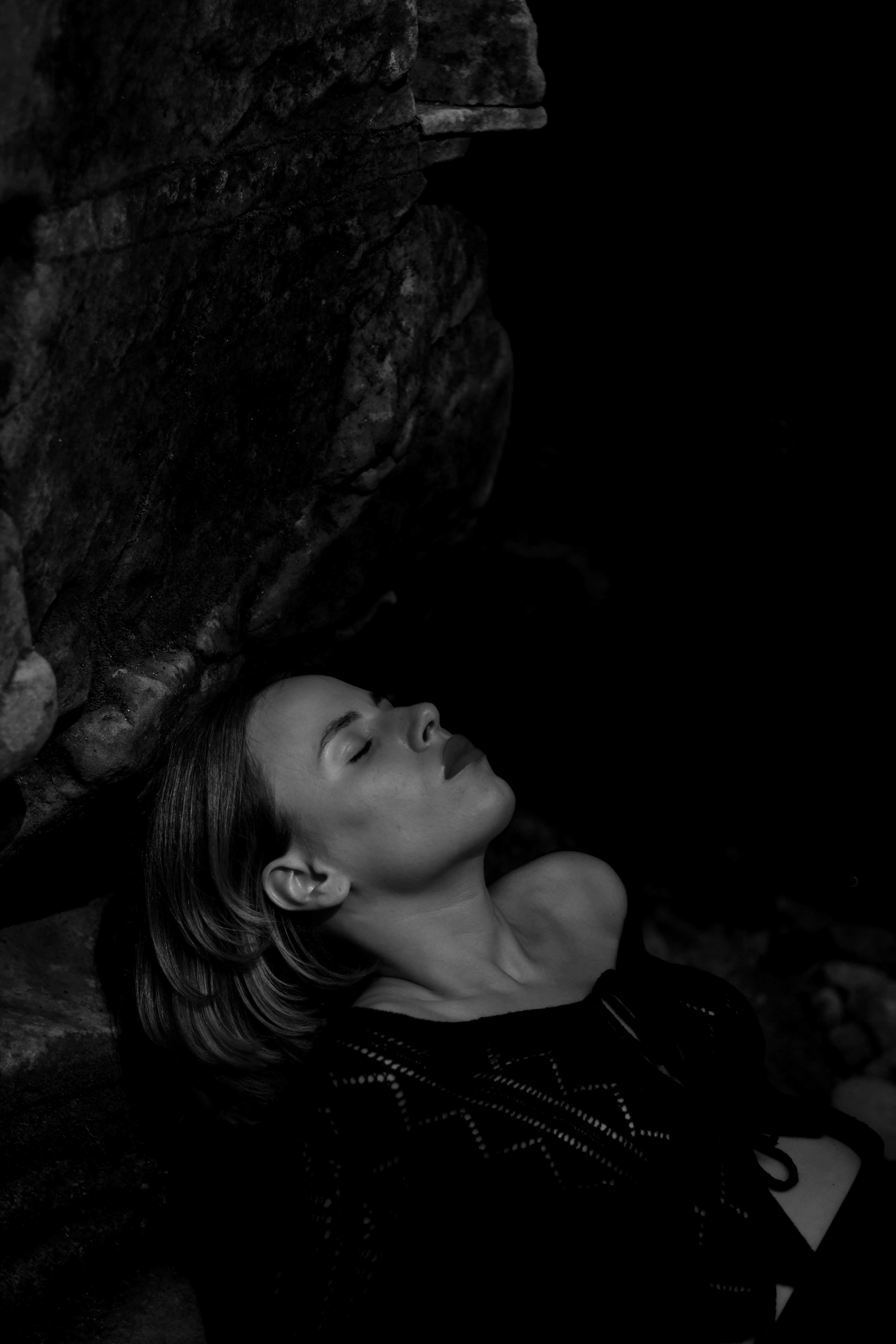 eine Frau, die neben einem Felsen auf dem Boden liegt