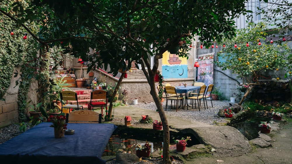 a patio with a table, chairs, and potted plants